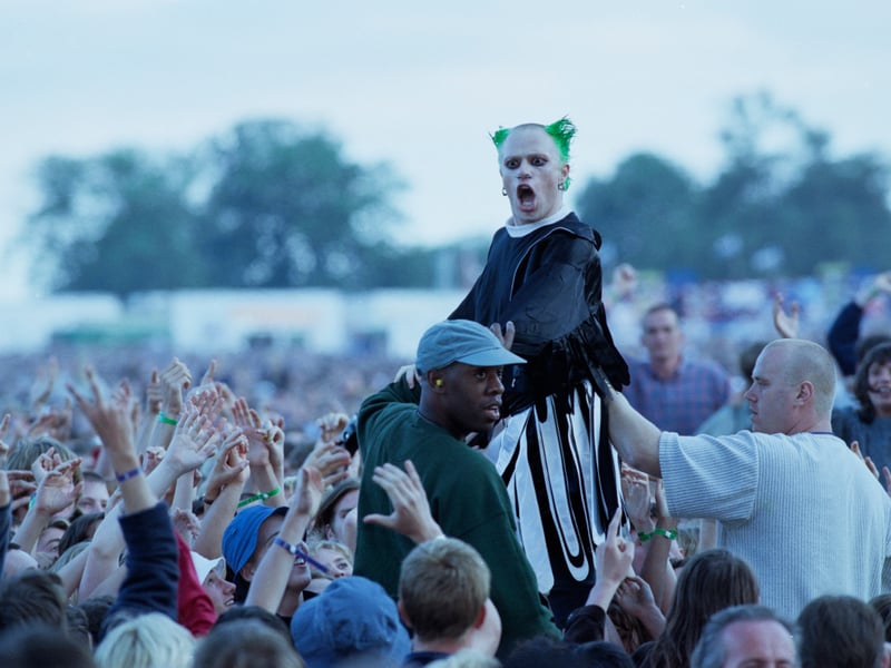 Keith Flint of The Prodigy leaves the stage to crowd surf over the audience during the group's support slot for rock group Oasis at Knebworth House in Hertfordshire, England on 10th August 1996.