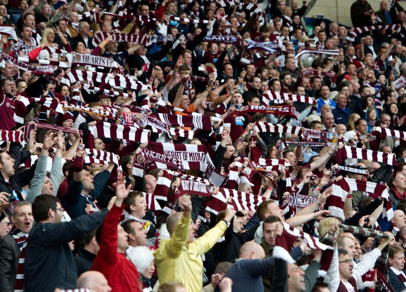 Hearts fans raise their scarves as their side roar to a famous win.
