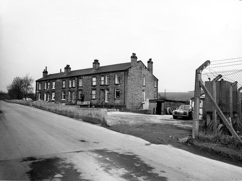 Woodview Terrace, a short terrace of houses on Quarry Lane, Woodkirk. On the right is a yard with a car, a garage and a shed with tyres piled up against it. Pictured in October 1980.