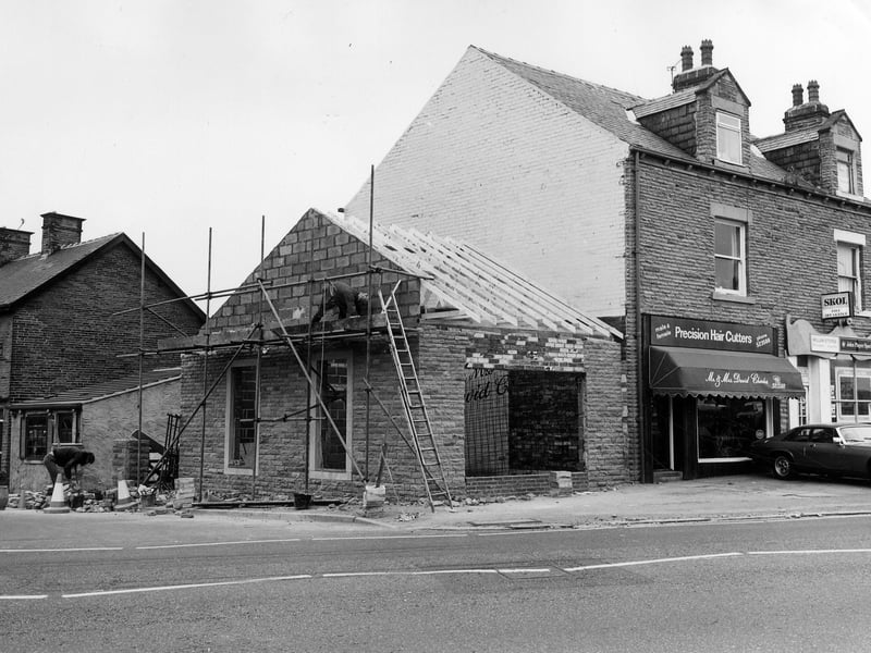Bradford Road by the junction with Beech Street, seen on the left. In the centre, a single storey extension is being built onto no. 29 Bradford Road, the premises of Mr. & Mrs. David Charles, Precision Hair Cutters. On the right, no. 31 is occupied by Millan Stores, off licence and cigarettes. Nos. 2 and 4 Beach Street are seen on the far left. Pictured in June 1983.