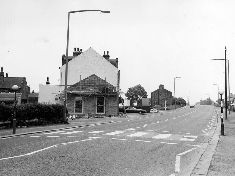Looking south-east along Bradford Road. To the left is the junction with Beech Street, then construction work is in progress on a single storey extension to no. 29, occupied by Mr. & Mrs. David Charles, Precision Hair Cutters. Further along is the junction with Fenton Street. On the right a sign for Ron White, sheet metal works, can be seen. Pictured in June 1983.