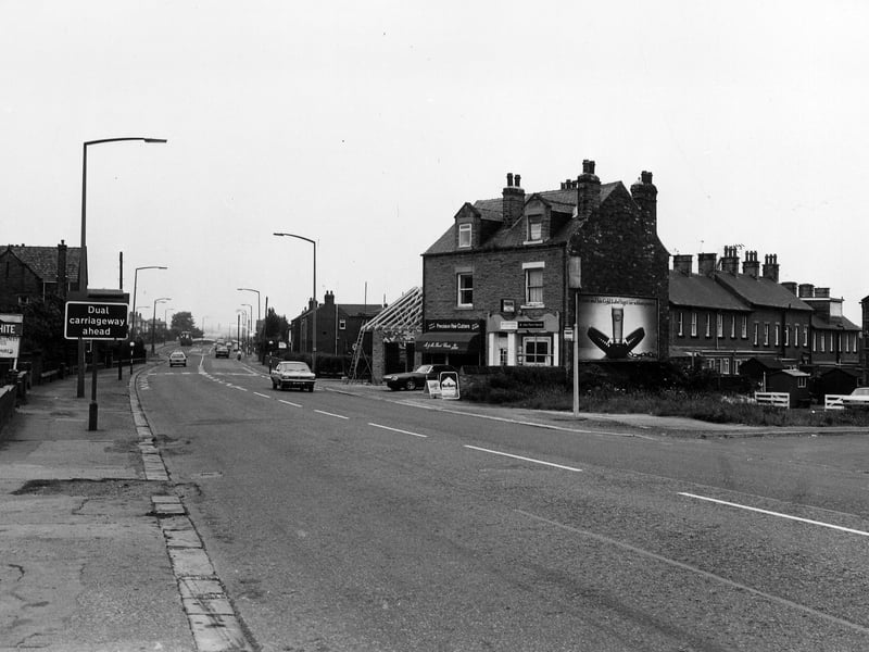 Looking north-west along Bradford Road from the junction with Fenton Street on the right. In the centre is a pair of shops, no. 31 (right) occupied by Millan Stores, off licence and no. 29 (left) Mr. & Mrs. David Charles, hairdressers, who are having an extension built to the side. Next to this is the junction with Beech Street.