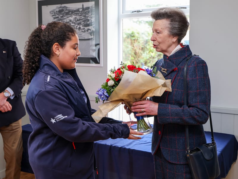 Pictured: HRH being presented with a posy of flowers by Miss Arrielle Deane, young crew member from the Royal Navy Sailing Association in Gosport.
