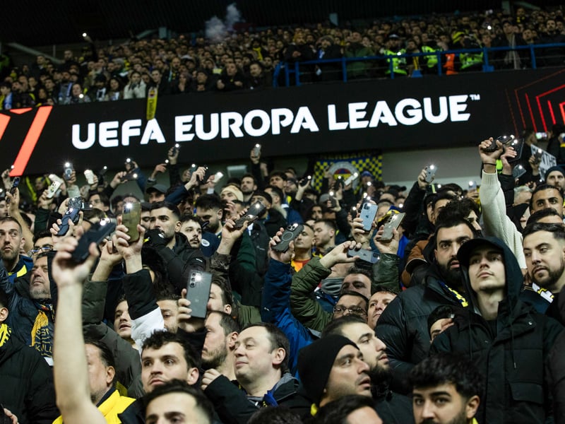 The Fenerbahce fans shine their phone torches.