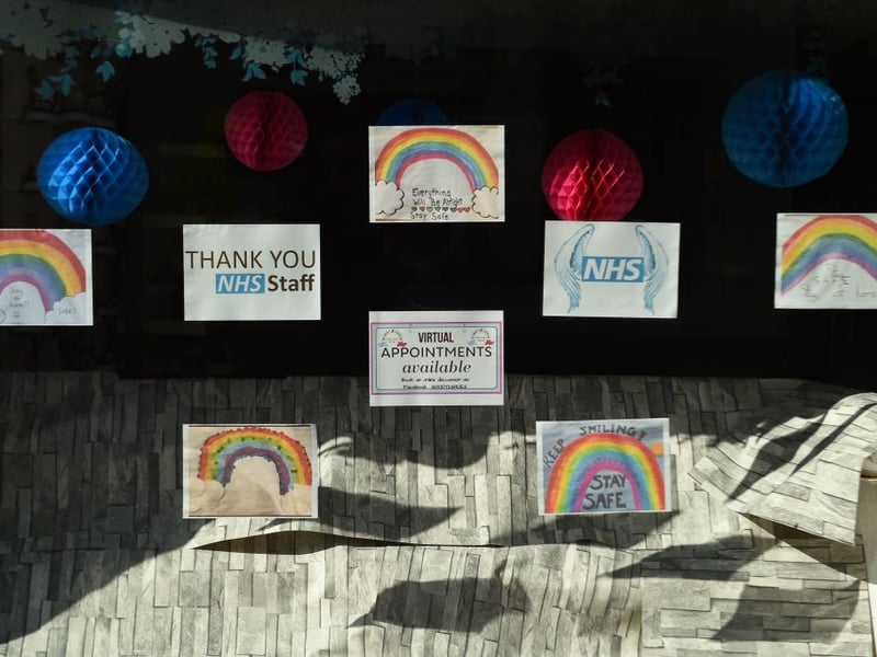 A collection of rainbow posters and tributes to NHS staff working during the coronavirus pandemic are seen in a closed shop in Ayr.