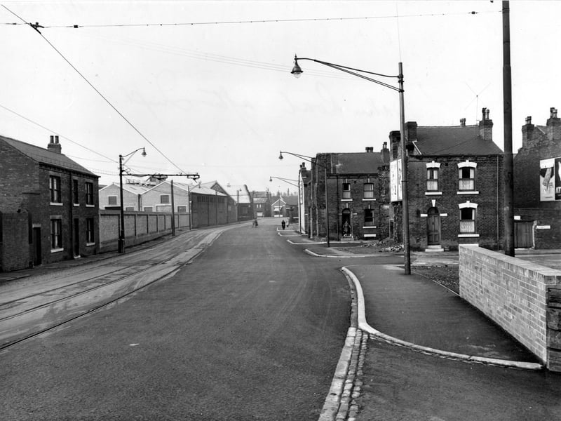  Looking north up Balm Road with Barmouth Road on the right in November 1955. The streets on the right have had their end houses demolished, replaced with new pavements and lamp posts. To the left of the road are tram lines with combined lamp posts and tram power cable supports. In the doorway of the first house on the second street is a woman standing and a child sat on the step.
