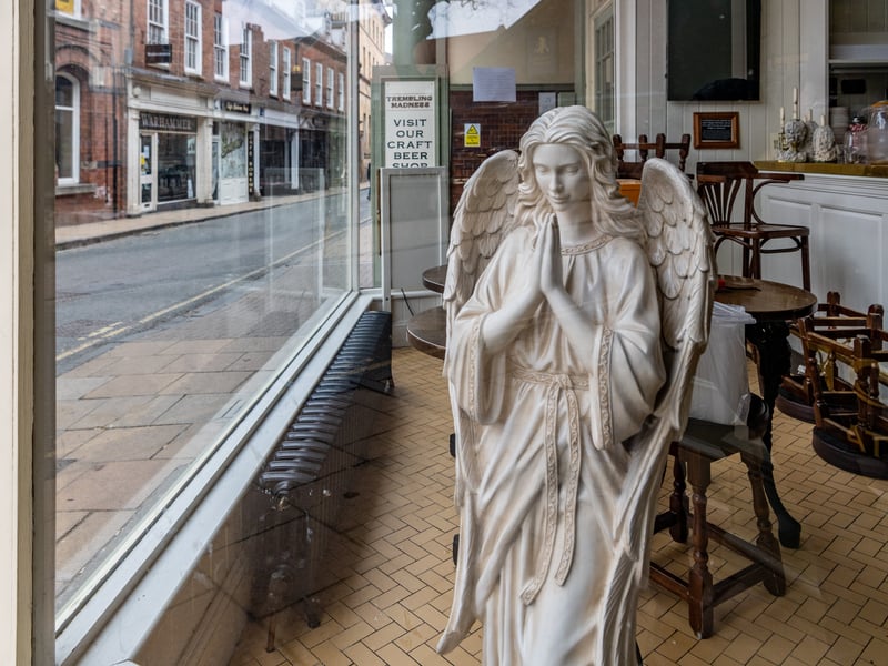 A praying angel in the window of the House Of The Trembling Madness, in Lendal, York, during the Covid pandemic in March 2020