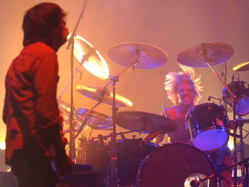 Drummer Taylor Hawkins (R) of the band Foo Fighters performs at the Wiltern Theatre on October 22, 2002 in Los Angeles, California
