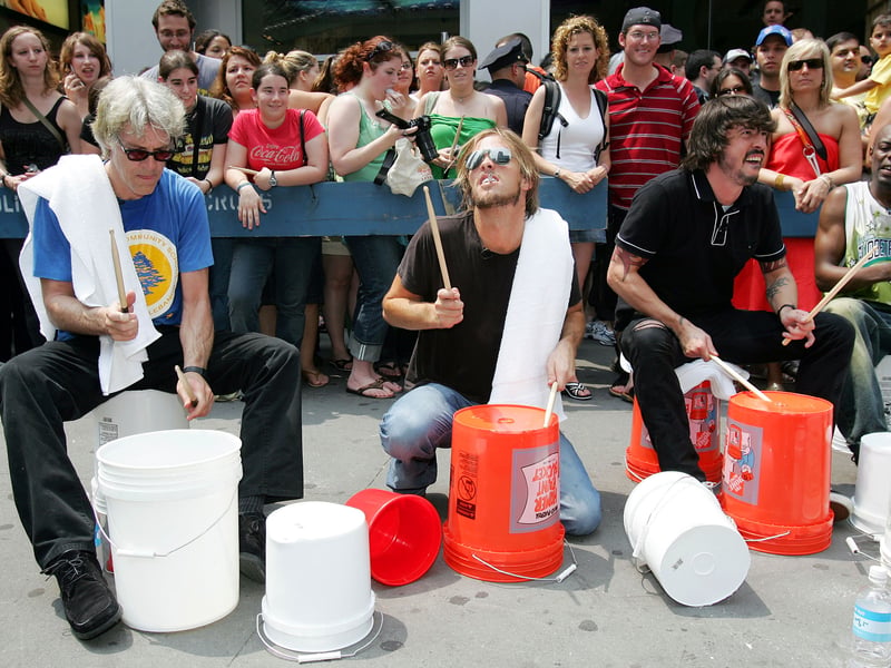 (L-R) Stuart Copeland of The Police, Taylor Hawkins and Dave Grohl of the Foo Fighters perform in a drum circle during MTV2's "24 Hours Of Foo" outside the MTV Times Square Studios June 11, 2005 in New York City.  
