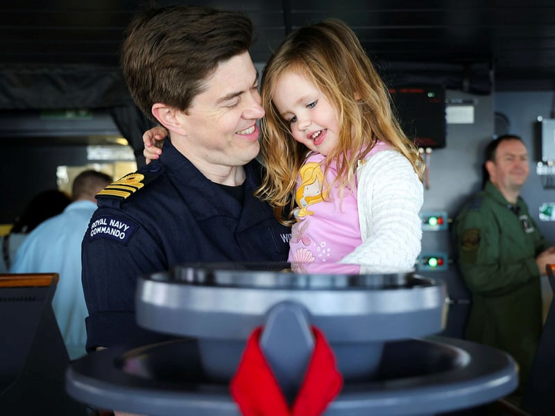 HMS Prince of Wales welcoming families and affiliates on board ahead of Indo-Pacific deployment. Pictured: Lieutenant Commander Winning with his daughter.
