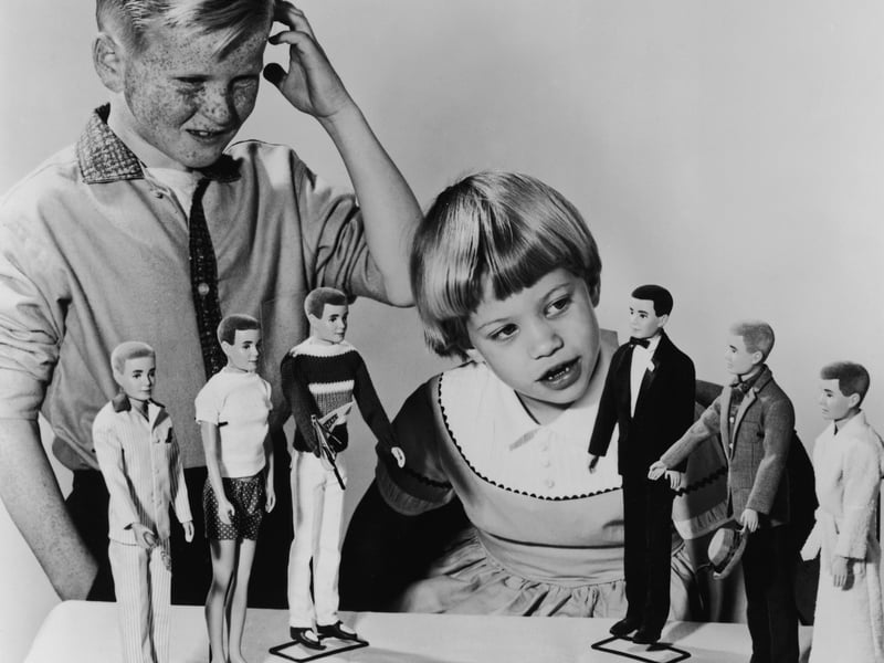 Barbie dolls were launched in 1959, with her male counterpart and love interest Ken joining the party two years later. Pictured here is a young girl inspecting the Ken dolls in 1961, while a boy scratches his head in confusion. Did you know, Ken's last name is Carson, while Barbie's surname is Roberts.