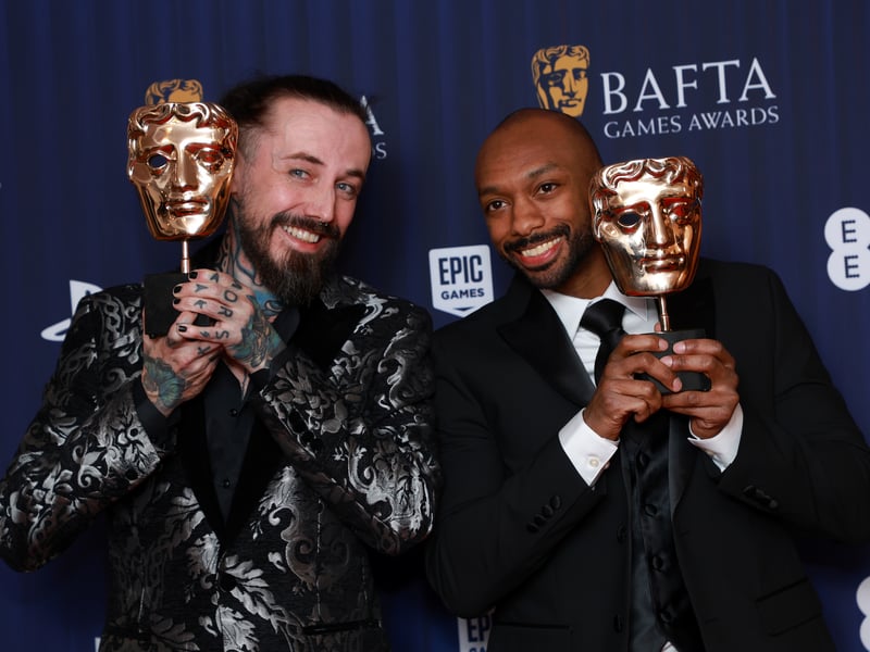 Composers Ross Tregenza and Wilbert Roget II pose in the winners room with the Music award for 'Helldivers 2' during the BAFTA Games Awards 2025.