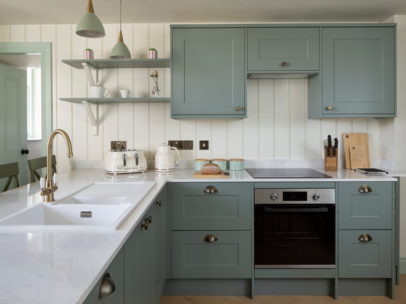 The kitchen is a modern shaker style with blue/grey cupboards.