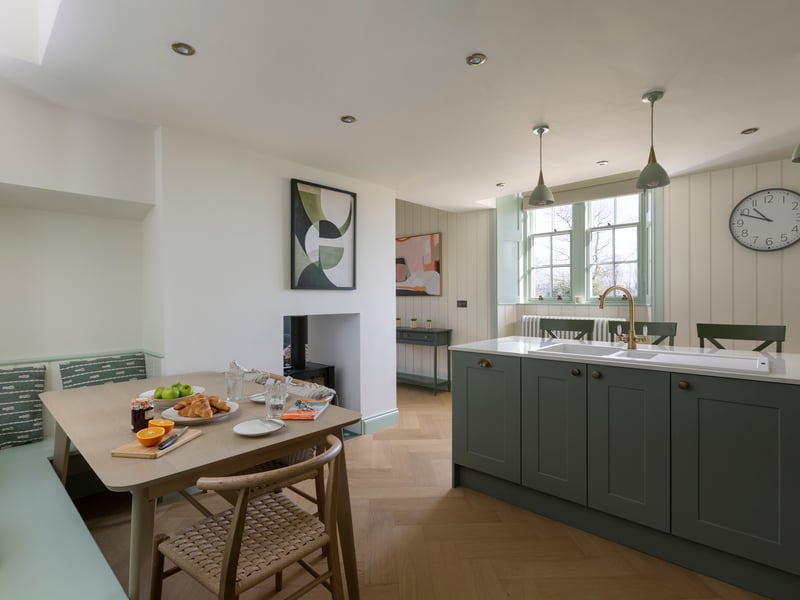 Guests can unwind in the open-plan living and kitchen area, warmed by a double-fronted wood burner.