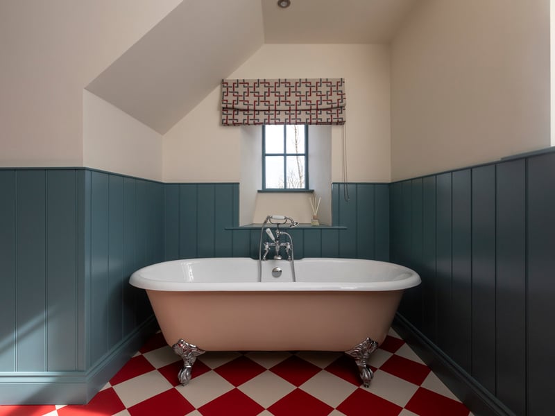 The large family bathroom features a walk-in shower and a large roll-top bath, perfect for a relaxing soak after a day of exploring the Estate.
