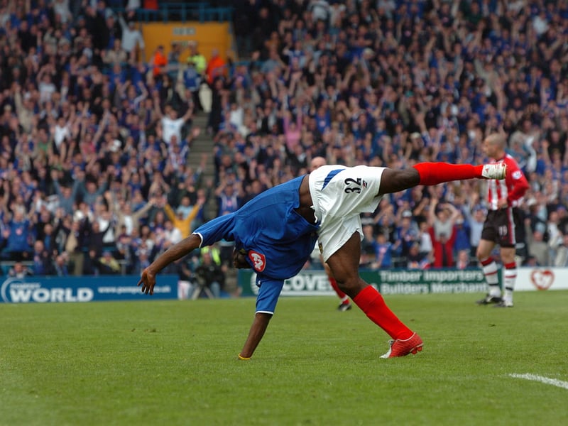 Lomana LuaLua does his iconic backflip as the Fratton faithful celebrate in the background.