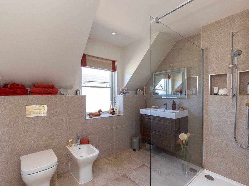The impressive modern en-suite shower room for the property's principal bedroom.