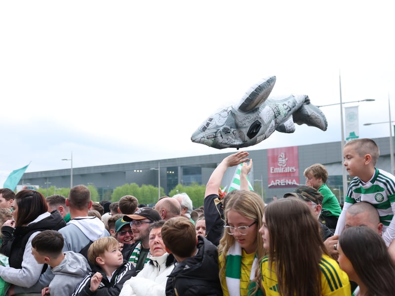 An inflatable shark is held up by Celtic fans.