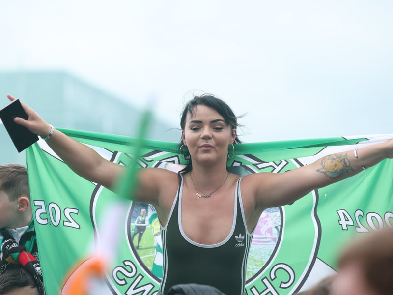 A Celtic fan celebrates the title win on Celtic Way.