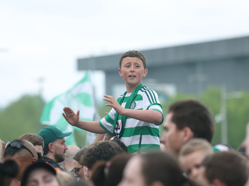 A young Celtic fan waits for the team after winning the Premiership title at Celtic Park.