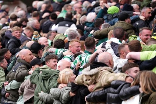 Celtic fans in the stands dance the Poznan during the Premiership match at Tannadice.