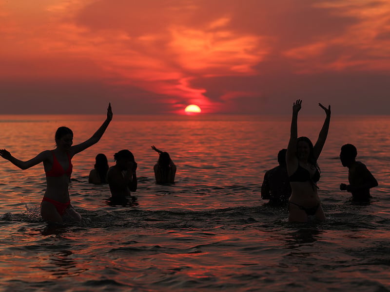 Swimmers were still enjoying the sea as the sun went down.