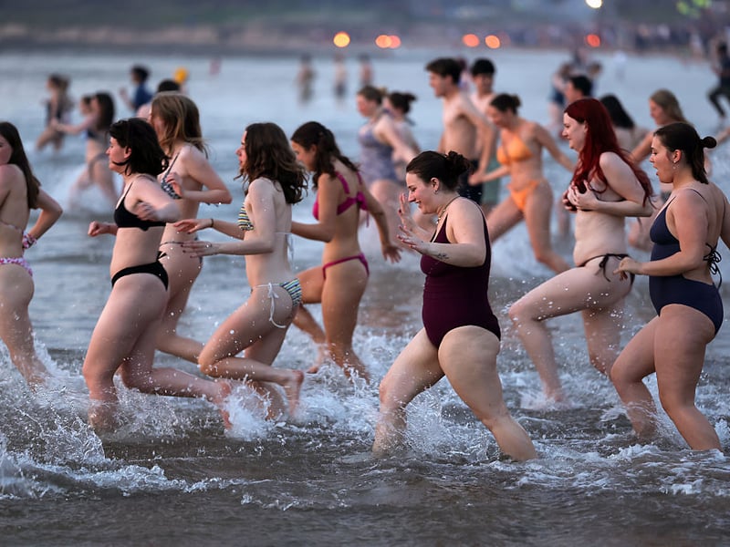 Bathers sprint into the sea.