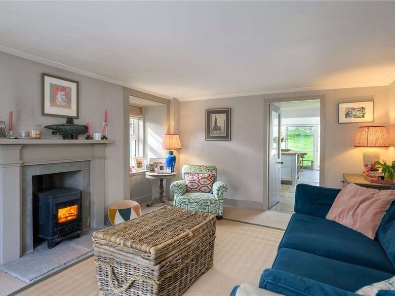 The living room is a cosy space with a wood burning stove.
