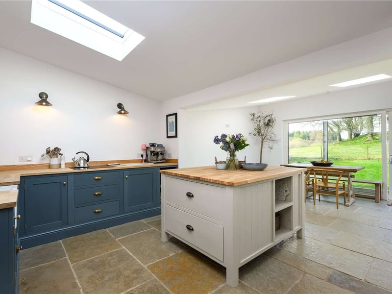 The large light-filled kitchen has an island and opens out to a dining area.