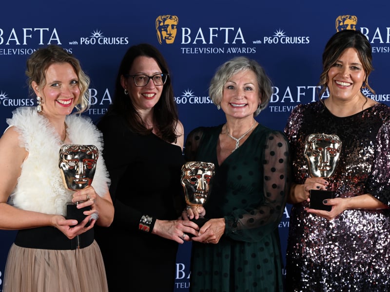 Elle While, Vanessa Amberleigh and Anna Perowne with a member of the cast and crew poses with the Scripted Award for 'CBeebies As You Like It at Shakespeare's Globe' inside the Winners Room at the 2025 BAFTA Television Awards.