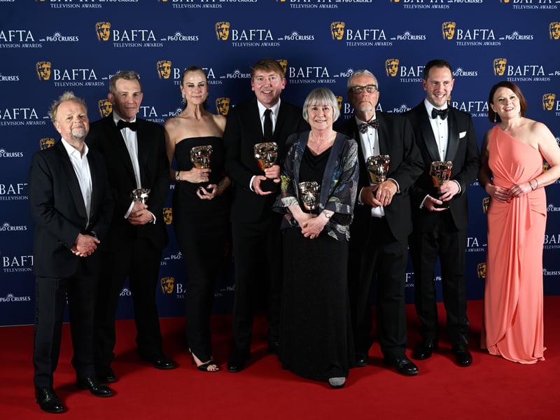 Toby Jones, Patrick Spence, Natasha Bondy, James Strong, Gwyneth Hughes, Chris Clough, a guest and Monica Dolan pose inside the Winners Room with the Limited Drama Award for 'Mr Bates vs The Post Office' at the 2025 BAFTA Television Awards.