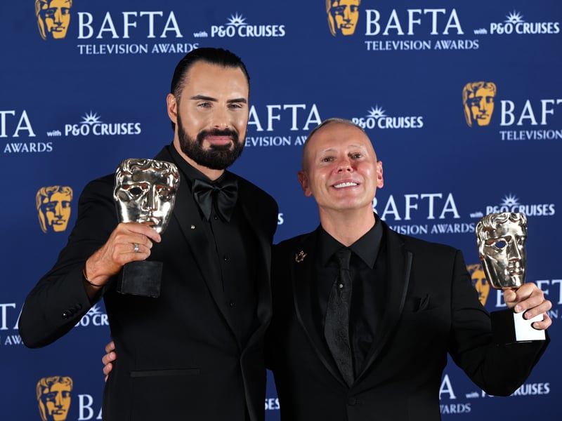 Rylan Clark and Robert Rinder pose with the Factual Entertainment Award for 'Rob and Rylan's Grand Tour' inside the Winners Room at the 2025 BAFTA Television Awards.