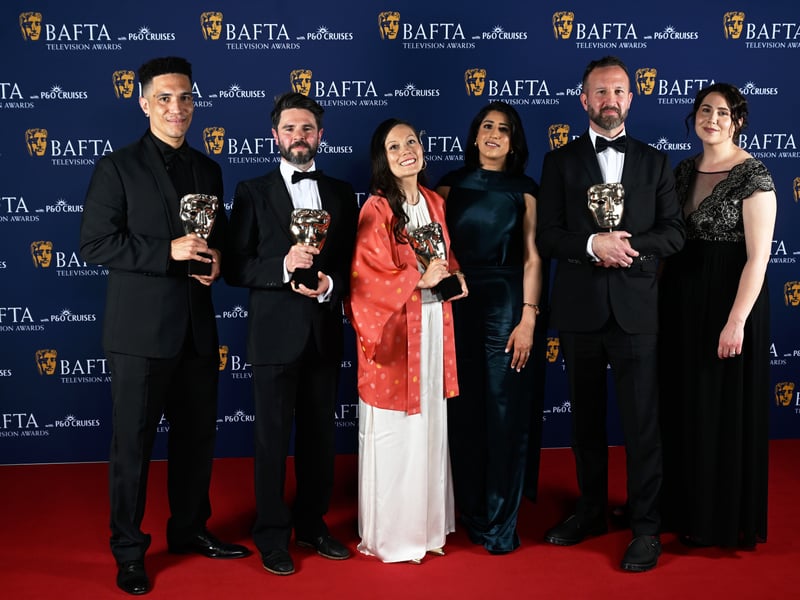 Otto Burnham, Benedict Sanderson, Megumi Inman, Morgan Matthews, Laura Mulleavy and member of cast and crew pose with the Specialist Factual Award for 'Atomic People' inside the Winners Room at the 2025 BAFTA Television Awards