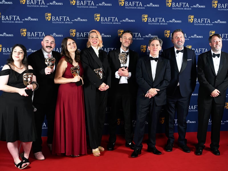 Jake Graham, Charlotte Bracey-Curant, Peter Holmes, Rob Brydon, Lee Mack, David Mitchell and members of cast and crew pose with the Entertainment Award for 'Would I Lie to You?' inside the Winners Room at the 2025 BAFTA Television Awards.
