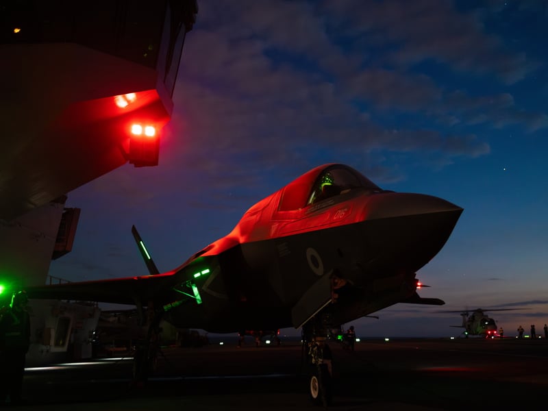 Pictured: AN F35b Lightning Jet is bathed in red light on the flight deck of HMS Prince of Wales during night flying operations for Exercise Med Strike during Operation Highmast as part of the UK Carrier Strike Group 2025.
