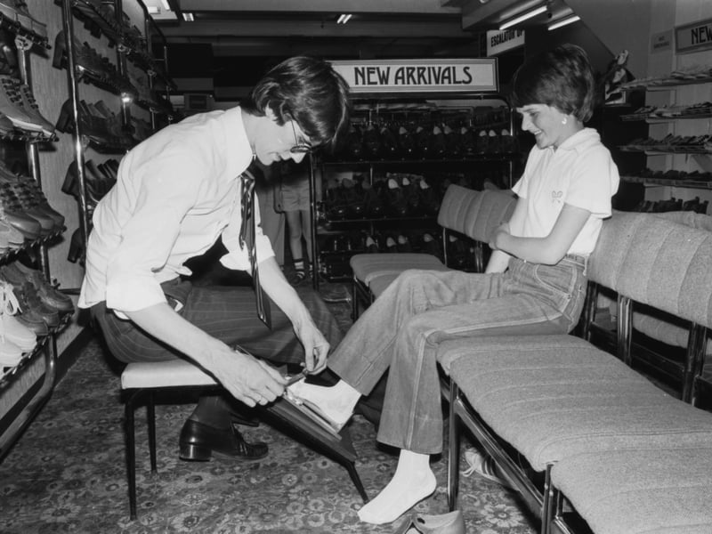 A shop assistant measures a girl's feet for new shoes at Arnotts department store in North Bridge Edinburgh, August 1979