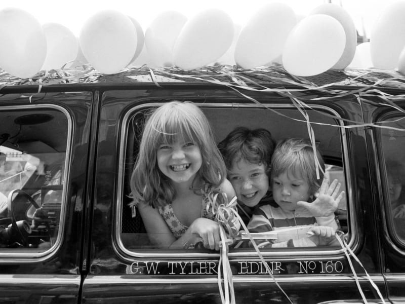 Children smiling from the window during the Edinburgh taxi drivers' outing for handicapped children procession in Princes Street  Edinburgh  in June 1979 - 