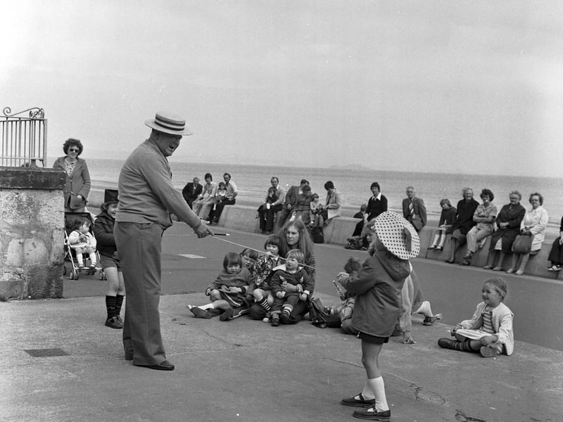 Uncle Erico and his young assistant do some magic tricks for the children on Portobello promenade in July 1979.