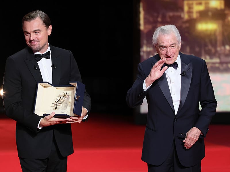 Robert De Niro accepts the honorary Palme d'Or from Leonardo DiCaprio.
