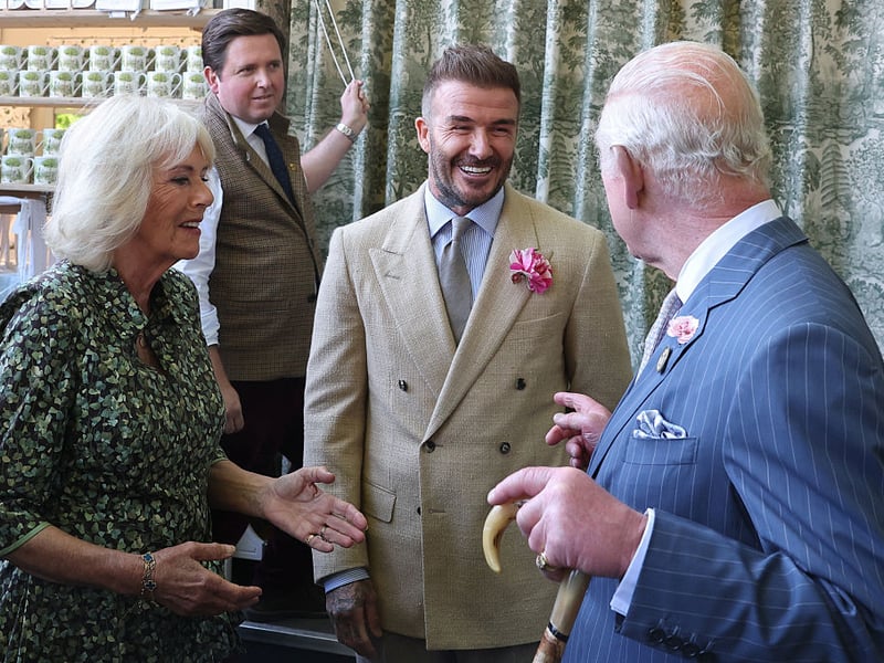 David Beckham, wearing a David Austin Roses 'King's Rose', speaks with King Charles III, patron of the Royal Horticultural Society, and Queen Camilla during a visit to the RHS Chelsea Flower Show.