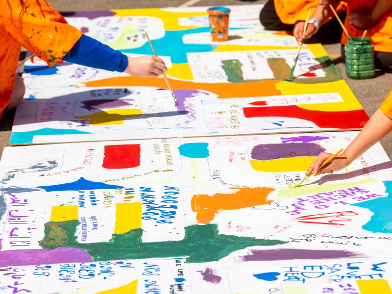 Children will write their translated phrase inside giant lettering that spells out the phrase.