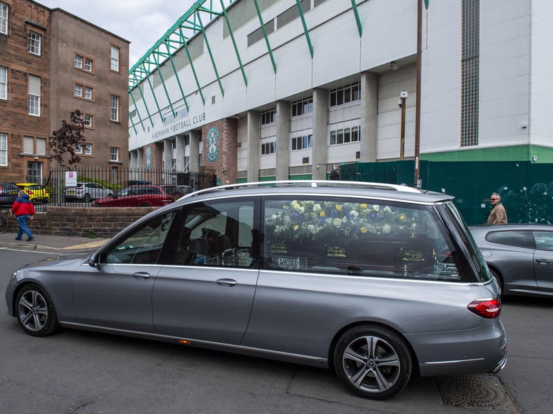 The hearse carrying Sir Tom Farmer's body moves out of shot and away from the waiting crowd.
