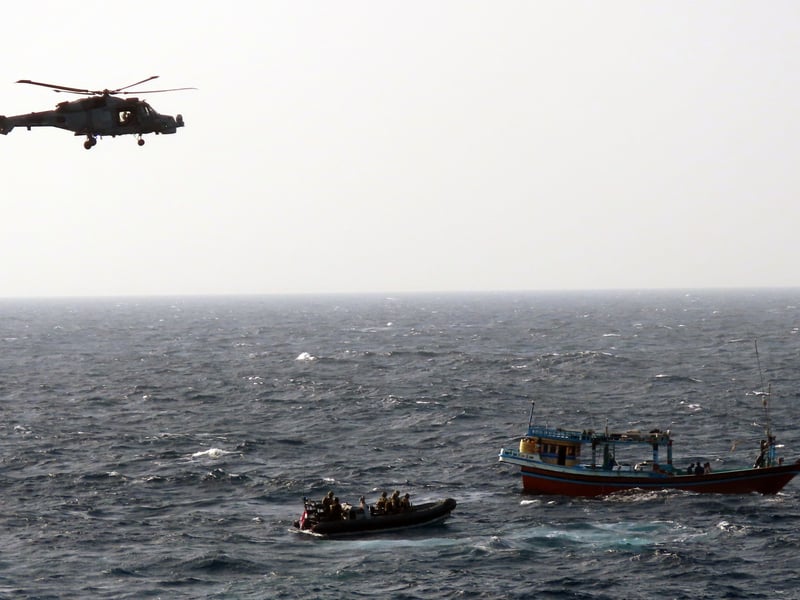 HMS Lancaster's Wildcat provides overwatch as the boarding team move in on the dhow