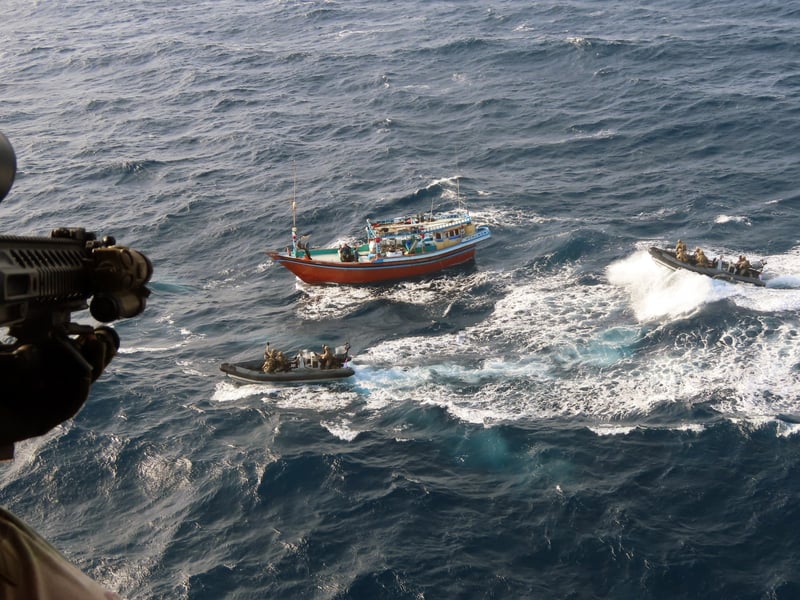The dhow crew hold their hands up in surrender as the Royal Marines close in.