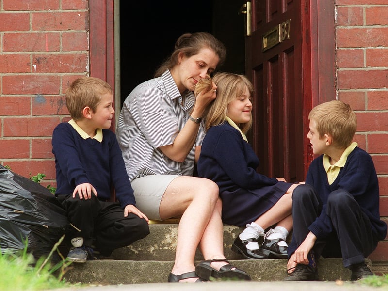 Pupils from Windmill Primary School were sent home after an outbreak of fleas. Patricia Trueman examines her children for the bugs at their home on Windmill Road.