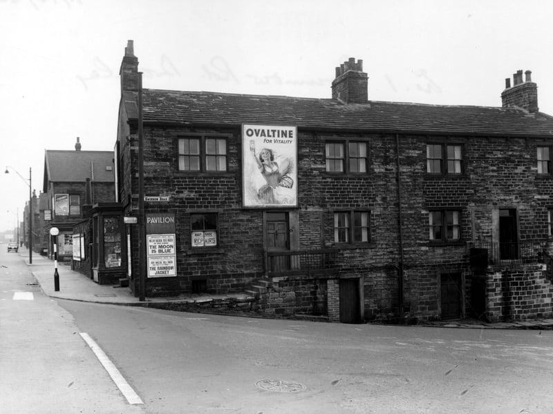 A view of number 491 Stanningley Road, (J. Turner, boot and shoe repairs) at its junction with Swinnow Road, on the right. A poster for Ovaltine and a programme bill for the Pavilion Cinema can be seen. A belisha beacon is to the left. Pictured in October 1954.