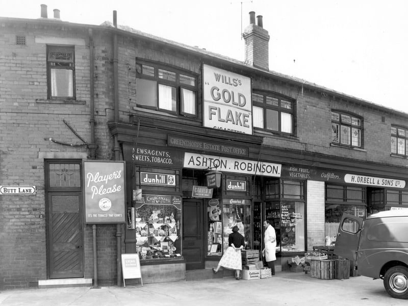 The west side of Butt Lane at the corner of Pudsey Road in May 1956. At number 2 Butt Lane is 'Ashton. Robinson, shopkeeper'. At number 203 Pudsey Road is 'H. Orbell & Sons Ltd, outfitters'.