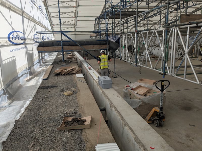 The team have started putting horizontal tiles around the edge of the pool, along with the black finger rests. Next, they will put the horizontal tiles on the other side of the drainage gulley.