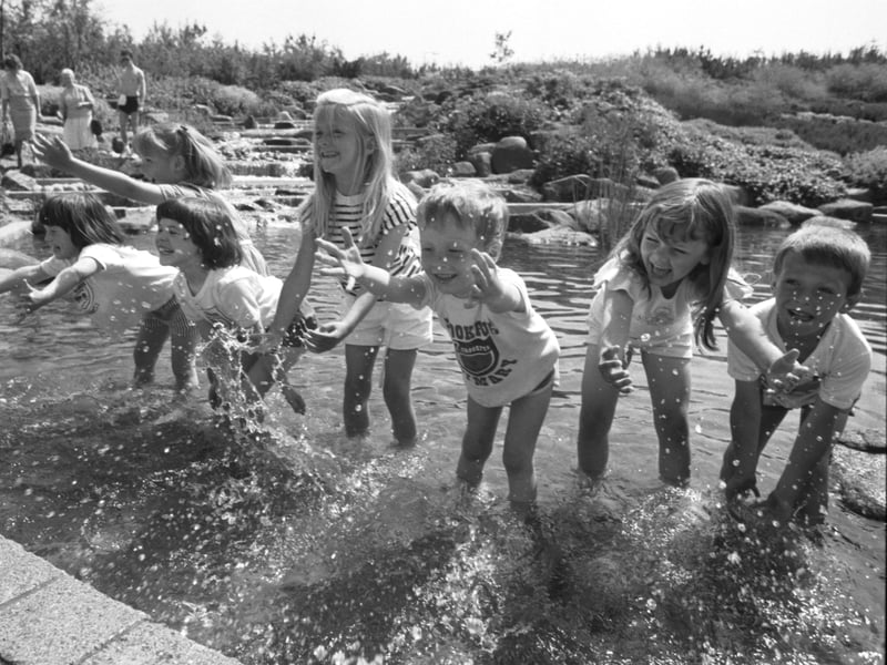 Children from Crookfur Primary School cool off in the waterfall when temperatures hit 75F at Glasgow Garden Festival in June 1988.