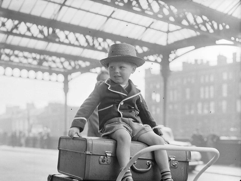 Glasgow Fair Holidaymakers at Glasgow Central Station in 1957- Three-year-old Paul Flannigan sits on top of luggage at Glasgow Central Station in 1957, ready to set off on an adventure during the Glasgow Fair holiday